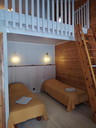 a room with two beds and a staircase at Hotelli Hirsiranta in Ruokolahti