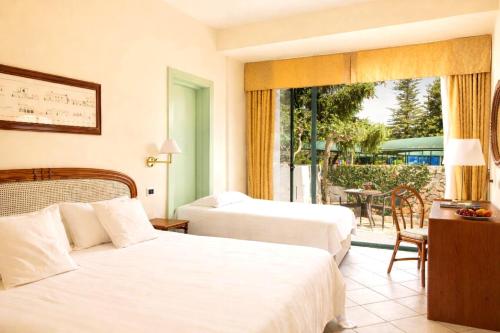 a hotel room with two beds and a balcony at Hotel Sierra Silvana in Selva di Fasano