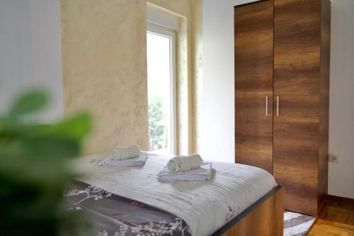 a bedroom with a bed with two towels on it at Apartman VIK in Brzeće