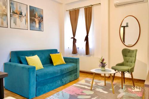 a living room with a blue couch and a chair at Apartman VIK in Brzeće