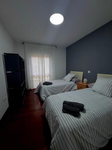 a bedroom with two beds and a light on the wall at Fuerte El Mazo in El Dueso