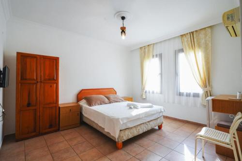 a bedroom with a bed and a dresser and window at The Dalyan's in Dalyan
