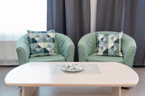 two chairs and a coffee table in a living room at Hotel Mezaparks in Riga