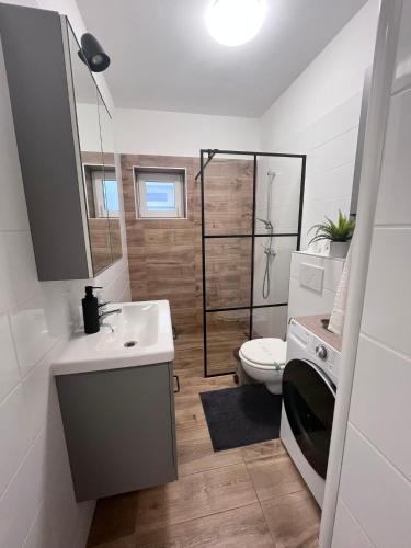 a bathroom with a toilet and a sink and a shower at Majoros Garden Apartman in Siófok