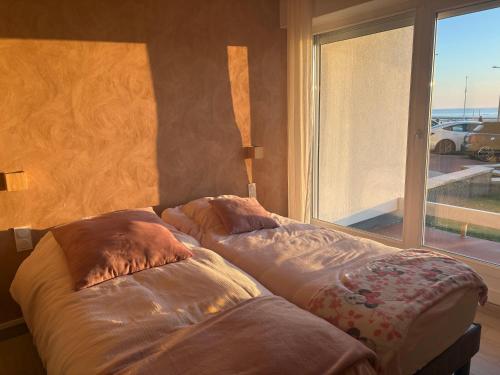 two beds sitting in a room with a window at Châteaux de Sable Hardelot in Neufchâtel-Hardelot