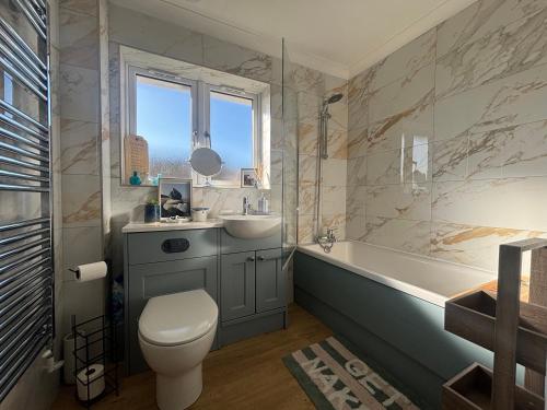 a bathroom with a sink and a toilet and a tub at Seaview in Lowestoft