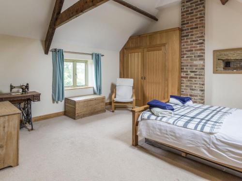 a bedroom with a bed and a desk and a chair at Orchard Cottage in Durham