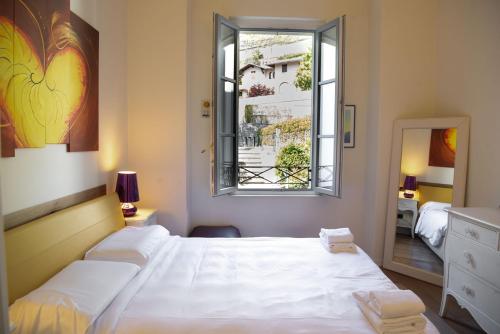 a bedroom with two beds and a window at Casa Julia - Menaggio by LoveComo in Menaggio