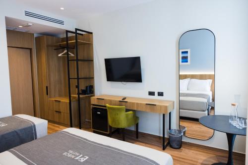 a room with a bed and a desk with a television at Mece Hotel Tirana in Tirana