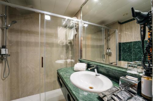 a bathroom with a sink and a glass shower at Abba Rambla Hotel in Barcelona