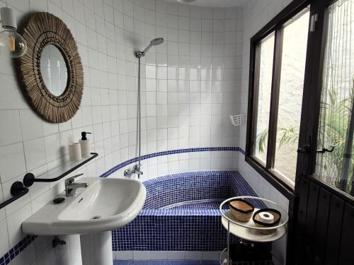 a blue and white bathroom with a sink and a shower at Casita Pablo in Agua Amarga