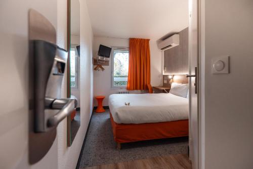 a hotel room with a bed and a window at The Originals Access, Hôtel Bordeaux Lac in Bruges