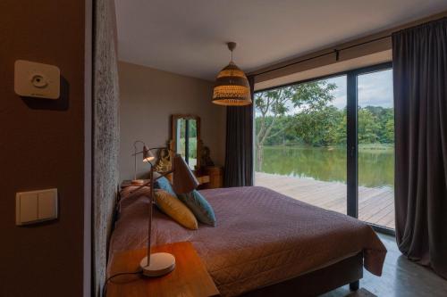 a bedroom with a bed with a view of a lake at ArtFolwark Wojnowo in Wojnówko