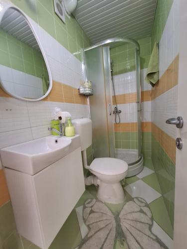 a bathroom with a toilet and a sink and a shower at Happiness Apartment Skopje in Skopje