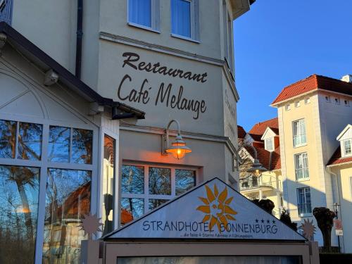 a building with a sign for a cafe welcome at Strandhotel Sonnenburg by ANS in Kühlungsborn