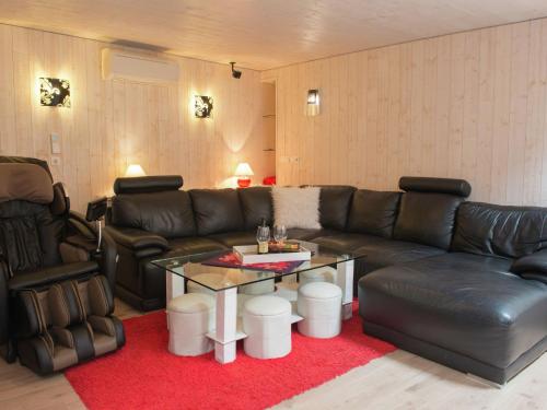 a living room with a leather couch and a table at Beautiful Apartment in Spa Belgium with Jacuzzi in Spa