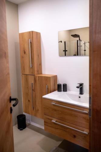 a bathroom with a sink and a mirror at Moderne Ferienwohnung nahe Salzburg & Eugendorf in Eugendorf