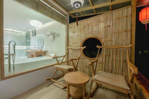 a room with two chairs and a table and a window at Chang'E Villa Rakthai in Ban Rak Thai