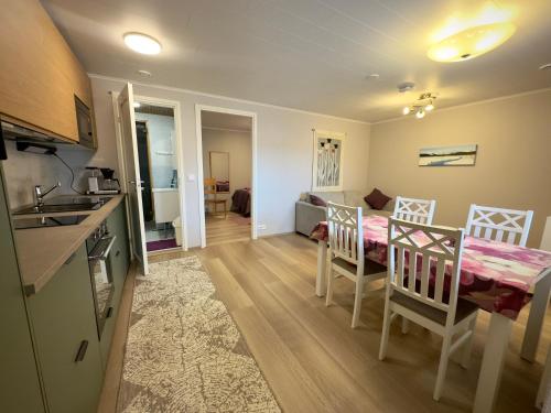 a kitchen and a living room with a table and chairs at Riihen Tupa in Äkäslompolo