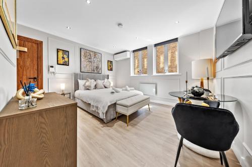 a bedroom with a bed and a table and a couch at The Liverpool Street Boutique in London