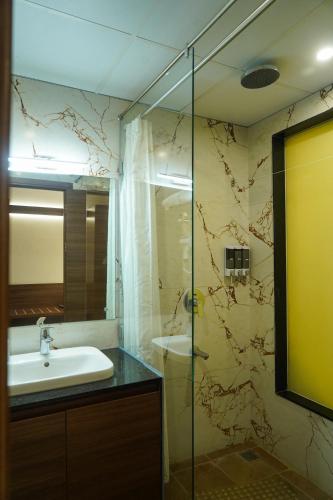 a bathroom with a sink and a shower at Highland Hotel in Bangalore