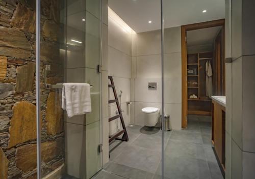 a bathroom with a glass shower and a toilet at Maanya by the Lake By Samav hotels in Udaipur