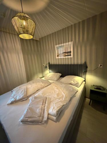 a bedroom with a bed with white sheets and a lamp at Vleijenhof Type B in Buren