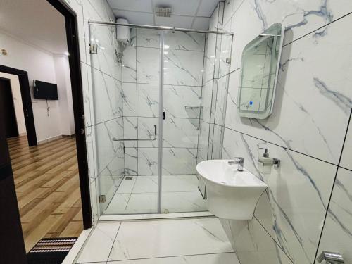 a bathroom with a shower and a sink at MIRACLE Inn in Alwaye