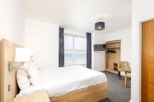 a hotel room with a bed and a window at The Sandringham Hotel in Weston-super-Mare