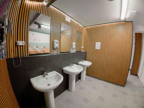 a bathroom with two sinks and a mirror and two toilets at Olé Backpackers Hostel in Alicante