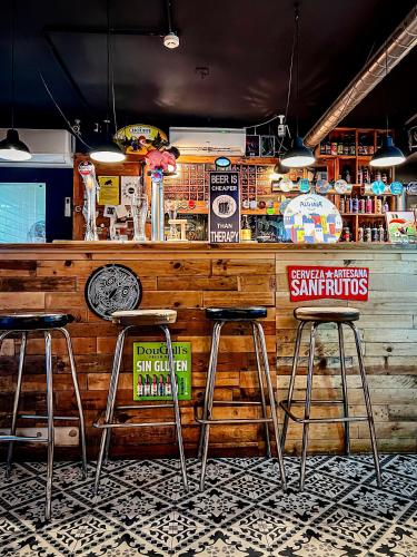 a bar with three bar stools in a restaurant at Olé Backpackers Hostel in Alicante