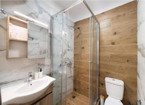 a bathroom with a shower and a toilet and a sink at 3 Keys Luxury Apartment in Nikiana