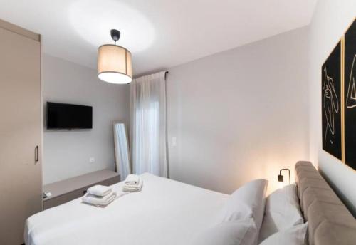 a bedroom with a white bed and a couch at 3 Keys Luxury Apartment in Nikiana