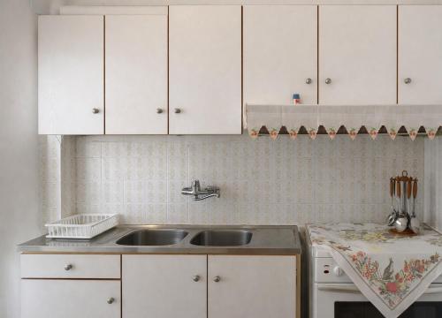 a kitchen with a sink and white cabinets at Beachfront Absolute Bliss in Perigiali, Korinthia in Periyiálion