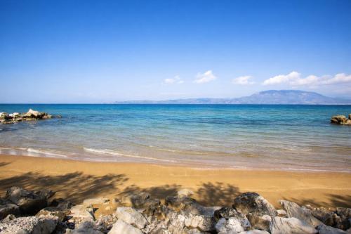 a beach with some rocks and the ocean at Beachfront Absolute Bliss in Perigiali, Korinthia in Periyiálion