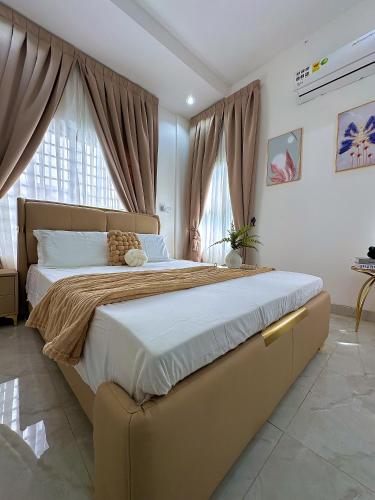 una grande camera da letto con un grande letto con tende di Chevy Chase Gardens a East Legon