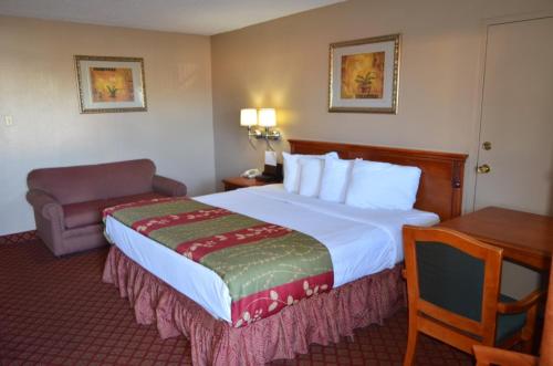 ein Hotelzimmer mit einem großen Bett und einem Schreibtisch in der Unterkunft Americas Best Value Inn Crosstimbers in Stephenville
