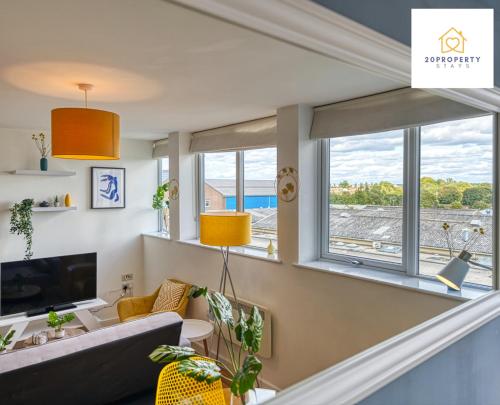 a living room with a couch and a large window at Contractors and Relocations Haven with Parking in Basingstoke