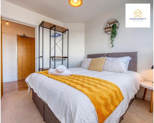 a bedroom with a large bed with a yellow blanket at Contractors and Relocations Haven with Parking in Basingstoke