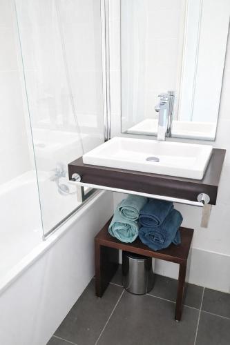 a bathroom with a sink and a table with towels at Studio LY'S in Saint-François
