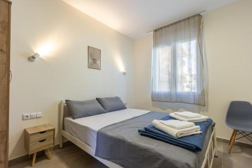 a bedroom with a bed with towels on it at Dimitra Beach Apartments 2 in Nea Karvali