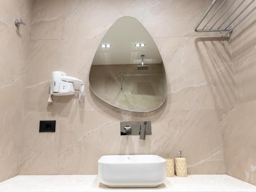 a bathroom with a sink and a mirror at Enigma Rooms in Lezhë