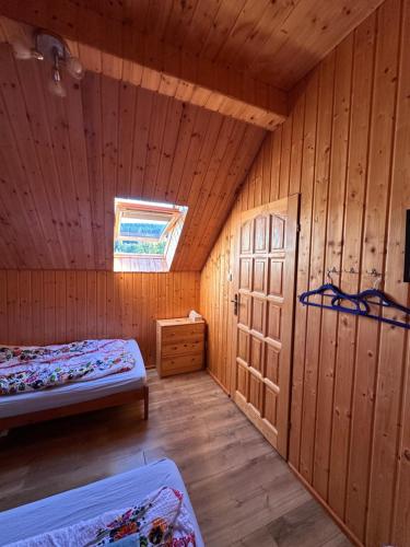 a room with two beds in a wooden cabin at Shambhala in Czarnów