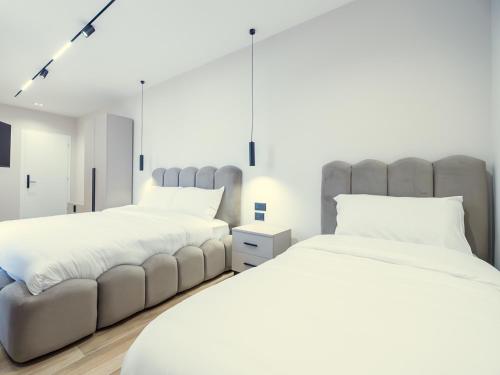 a bedroom with two beds and a couch at Enigma Rooms in Lezhë