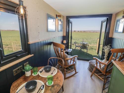 a room with a table and chairs and a window at GiGi's Horsebox in Evesham