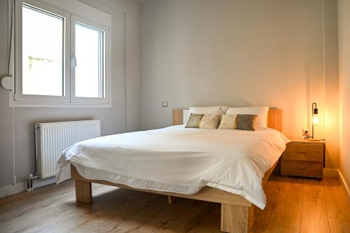 a bedroom with a large white bed and a window at Thessaloniki Central Luxe in Thessaloniki
