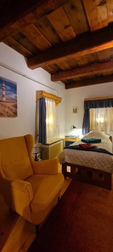 a bedroom with a bed and a couch and a chair at Napsugár Vendégház Nagylóc in Nagylóc