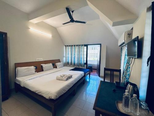 a bedroom with a large bed with a ceiling fan at HOTEL IHAM PARADISE - Near Mangalore Central Railway Station - Pets Not Allowed in Mangalore