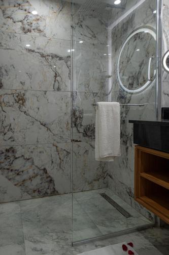 a bathroom with a shower with a glass door at Iconic Plaza Hotel in Nairobi