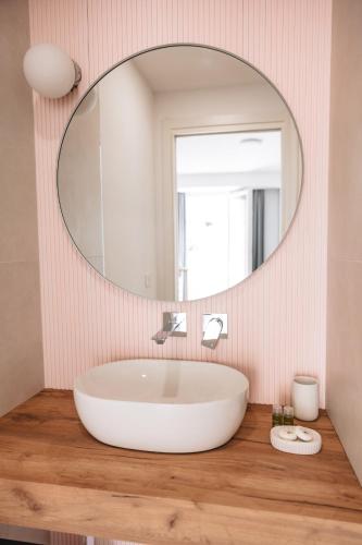 a bathroom with a large white tub and a mirror at City Boutique in Porto Torres